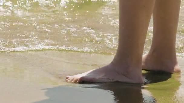 Feminino fica na areia molhada e ondas na praia — Vídeo de Stock