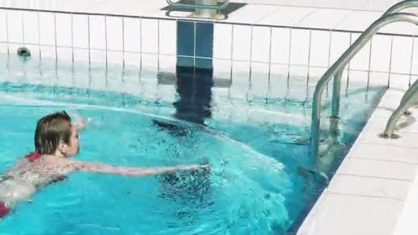 Женщина в красном бикини выходит из бассейна — стоковое видео