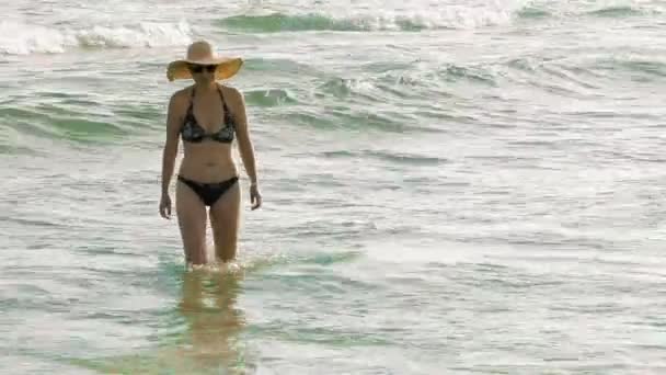 En kvinna går felfritt mot stranden — Stockvideo
