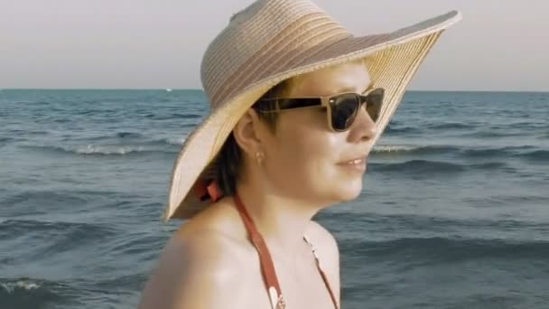 Een vrouw die lopen op het strand bij de zonsondergang zonsopgang — Stockvideo