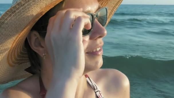 Mujer en bikini sombrero de paja posponiendo gafas de sol — Vídeo de stock