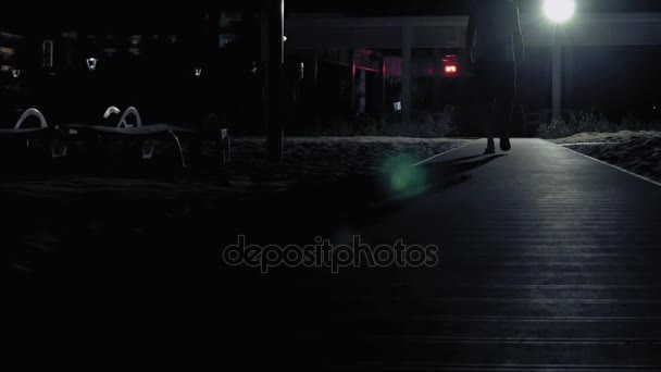 Un hombre camina solo en la oscuridad en las calles — Vídeo de stock