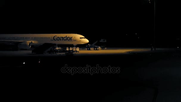 Avión está parado en el aeropuerto por la noche — Vídeo de stock