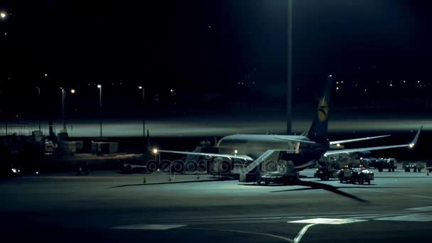 Repülőgép áll még a repülőtéren, az éjszakai — Stock videók