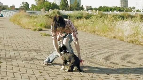 Jonge vrouw met schattig hondje buiten spelen — Stockvideo