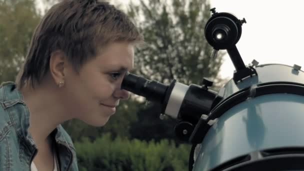 Жінка дивиться на Місяць через телескоп — стокове відео