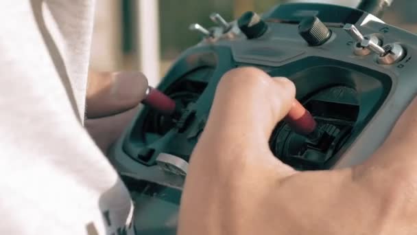 Mãos segurando um transmissor controlando o drone FPV — Vídeo de Stock
