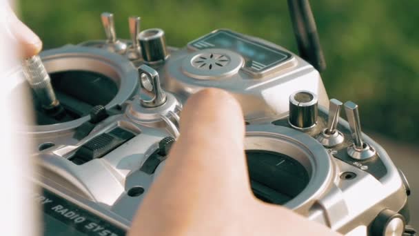 Mãos segurando um transmissor controlando o drone FPV — Vídeo de Stock