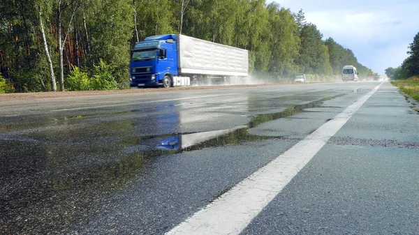 Tráfico en carretera mojada con salpicaduras de niebla — Foto de Stock