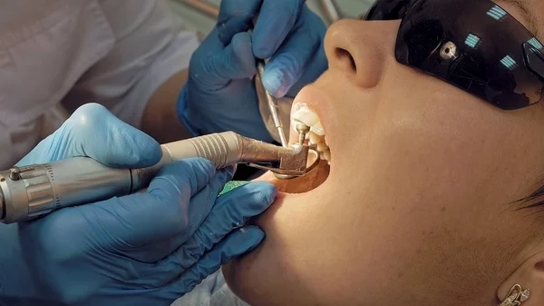 Nainen hammaslääkäriasemalla hoidettavana — kuvapankkivalokuva