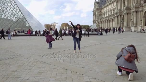 Muchacha de pie cerca de la pirámide de vidrio en el patio del Louvre — Vídeos de Stock