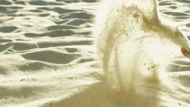 Человек в шортах цвета хаки просеивает песок ногами — стоковое видео