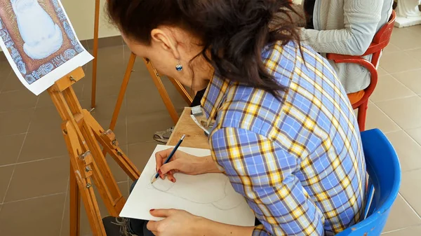 Kvinnlig konstnär ritar en blyertsskiss i art studio — Stockfoto