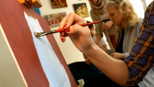 Female artist paints picture artwork in art studio — Stock Photo, Image
