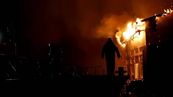 Casa em chamas. Conflagração. Bombeiro combate fogo . — Fotografia de Stock