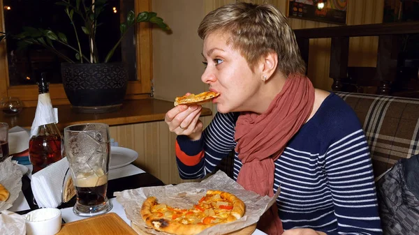 Csinos szőke nő pizzát eszik, és iszik sört — Stock Fotó