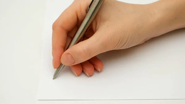 Female hand writes on the paper sheet — Stock Photo, Image