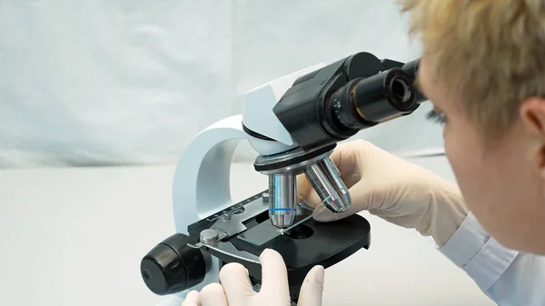 顕微鏡を通して見る女医科学者 — ストック写真