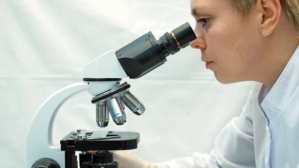 Female doctor scientist looking through microscope — Stock Photo, Image