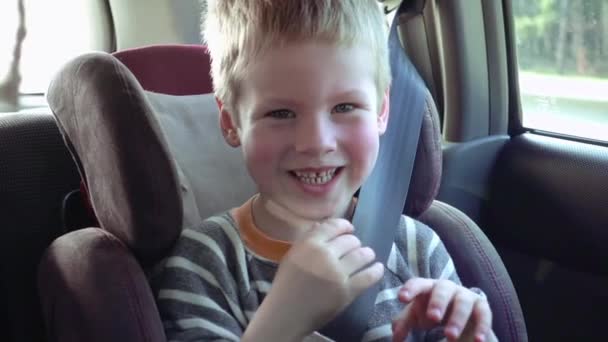 Cute boy in a child car seat smiles and laughs — Stock Video