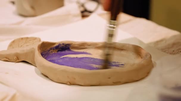 Ceramist is painting clay pot or vase bowl — Stock Video