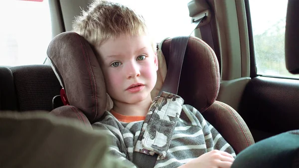 Schattige jongen in een kinderzitje auto — Stockfoto