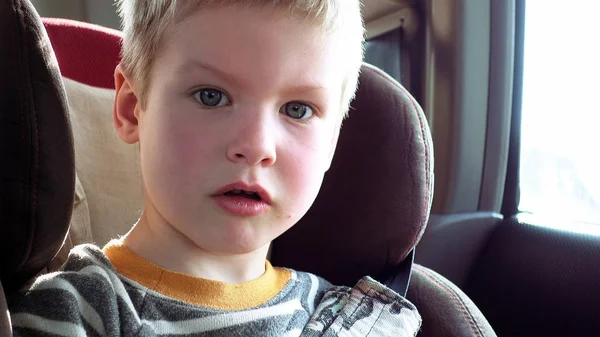 Schattige jongen in een kinderzitje auto — Stockfoto