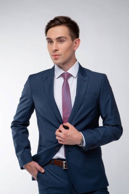 Siyah kısa saçlı, beyaz gömlekli, beyaz gömlekli, atölyesinde beyaz bir kravatı olan genç, yakışıklı bir adam.