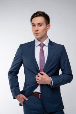 Siyah kısa saçlı, beyaz gömlekli, beyaz gömlekli, atölyesinde beyaz bir kravatı olan genç, yakışıklı bir adam.