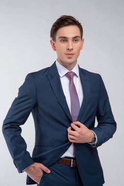 Siyah kısa saçlı, beyaz gömlekli, beyaz gömlekli, atölyesinde beyaz bir kravatı olan genç, yakışıklı bir adam.