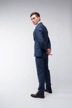 Siyah kısa saçlı, beyaz gömlekli, beyaz gömlekli, atölyesinde beyaz bir kravatı olan genç, yakışıklı bir adam.