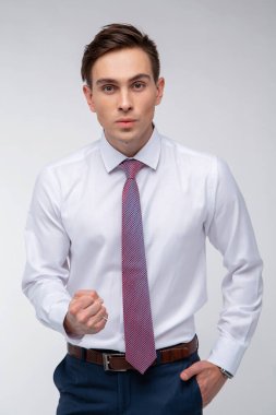 Siyah kısa saçlı, beyaz gömlekli, beyaz gömlekli, atölyesinde beyaz bir kravatı olan genç, yakışıklı bir adam.