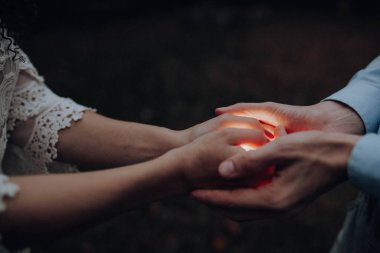 Işığı tutan kadın ve erkeğin elleri