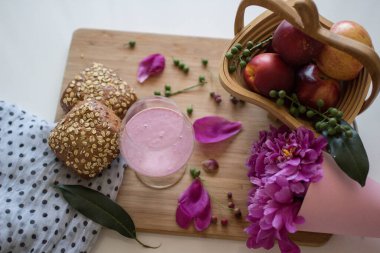 Sepette elmaların, çöreklerin, kokteyllerin ve taze çiçeklerin üst görüntüsü 