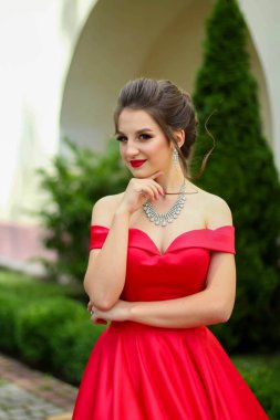 Açık havada kırmızı elbiseli güzel bir kadının portresi..