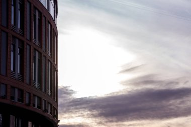 Ofis binasının modern cephesi, çelik bir yapıda parlak pencereleri olan soyut bir parçadır. Kartvizit, el ilanı, yazı veya logo için yeri olan afiş için harika bir arkaplan