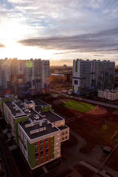 Urban industrial landscape in the evening at sunset. Beautiful blue sky, creative business buildings and residential buildings. Panoramic image from a height