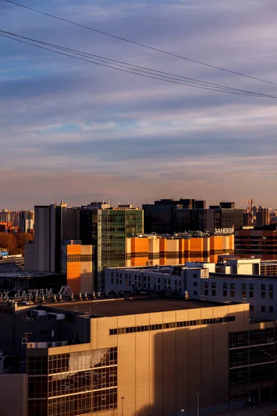 Urban industrial landscape in the evening at sunset. Beautiful blue sky, creative business buildings and residential buildings. Panoramic image from a height