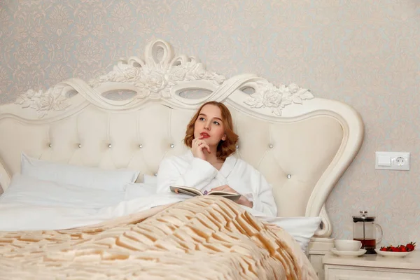 Eine Schöne Junge Blondine Hausmantel Sitzt Auf Einem Schicken Bett — Stockfoto