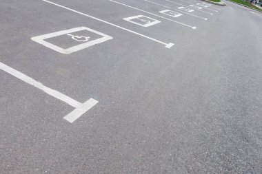 Engelliler için park yeri. Asfalttaki engelli park yeri için beyaz işaret. Engelli park yeri