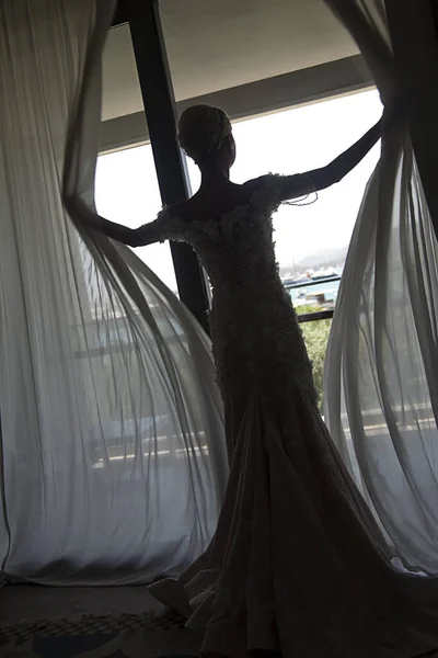 婚礼早上 新娘打开窗帘 身着婚纱的女孩站在窗前 拉开窗帘 今天是晴天 外面晴天 — 图库照片