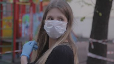 Sokakta maskeli ve lastik eldivenli bir kız. Kadın çıkar ve kötü havada tıbbi maske takar. Yakın plan genç kadın Slav görünüşü. Virüslerden korunma kavramı. Covid-19 salgını