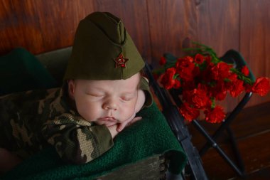 Üniformalı yeni doğmuş bir çocuk 9 Mayıs 1941 - 1945 tarihleri arasında Rusya 'da bir askerin oğlu olan Zafer Günü için çekmecede yatıyor.