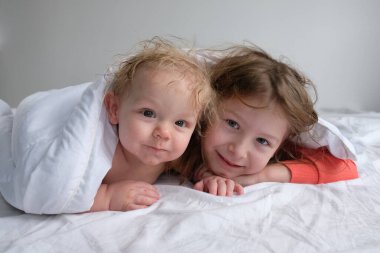 Erkek ve kız kardeşler evde, çocuklar hasta, çocuklar için karantina, küçük çocuklar için günaydın, mutlu çocuklar yatak odasında.