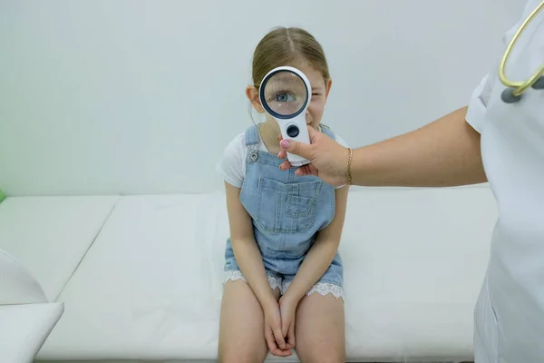 Gadis Kantor Dokter Duduk Sofa Dan Memeriksa Penglihatannya Melalui Pembesarnya — Stok Foto