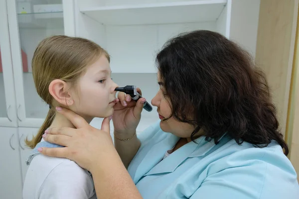 用放大镜在儿科医生的儿童医院里的孩子 近视医生的手与现代耳镜检查女孩的鼻子 儿童健康和疾病预防 — 图库照片