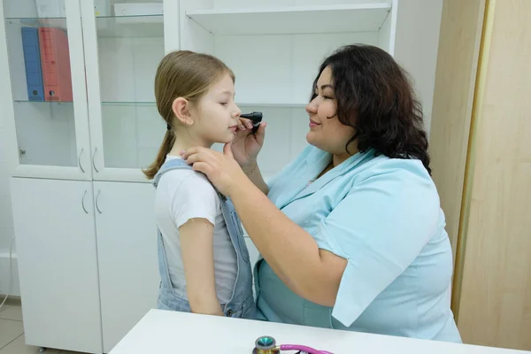 用放大镜在儿科医生的儿童医院里的孩子 近视医生的手与现代耳镜检查女孩的鼻子 儿童健康和疾病预防 — 图库照片