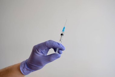 Beyaz arka planda bulunan korona salgınına karşı kovid-19 virüsü için el ele tutuşma şırıngası ve aşı