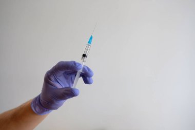 Beyaz arka planda bulunan korona salgınına karşı kovid-19 virüsü için el ele tutuşma şırıngası ve aşı