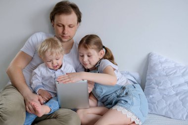 Mutlu bir aile evde vakit geçirir. İki çocuklu bir baba çizgi film izler ve dizüstü bilgisayarda oyunlar oynar. Babası kızı ve oğlu kucaklıyor.